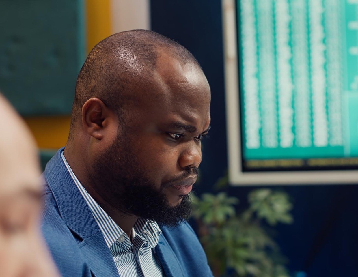 An analyst at work with dashboards on screen behind them