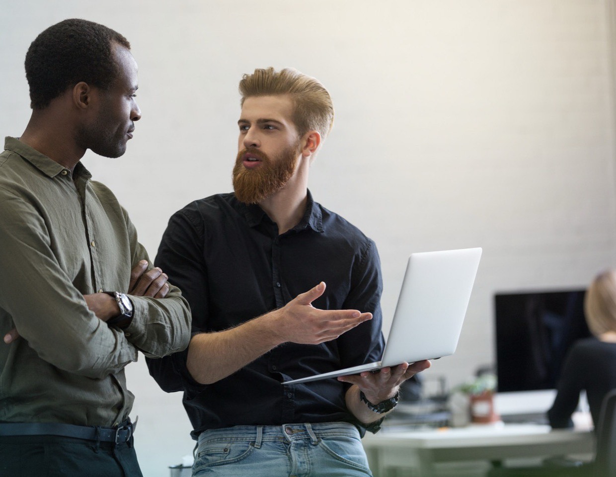 Two colleagues reviewing work together at a laptop